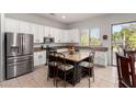 Bright kitchen featuring a center island with seating, stainless steel appliances, and ample cabinet space at 9360 E Milagro Ave, Mesa, AZ 85209