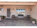 Charming front porch seating area, perfect for relaxing, with stone flooring and stylish decor at 11413 E Neville Ave, Mesa, AZ 85209