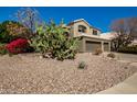 Southwest house featuring desert landscaping and a white tile roof, creating a picturesque setting at 1202 E Desert Broom Way, Phoenix, AZ 85048