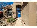 Inviting front entrance with a blue door, arched window, and charming landscaping at 1202 E Desert Broom Way, Phoenix, AZ 85048