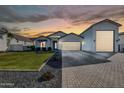 Beautiful single-story home at sunset featuring a 3 car garage and a well-maintained yard at 1291 E La Fortuna Ct, San Tan Valley, AZ 85140