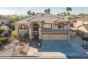 Elegant two-story home with a grand entrance, three-car garage, and beautiful desert landscaping at 12925 W Llano Dr, Litchfield Park, AZ 85340