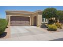 A home featuring desert landscaping, neutral paint, a large garage and a security camera at 12956 W Eagle Ridge Ln, Peoria, AZ 85383