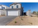 Two-story home featuring a two-car garage, complemented by desert landscaping, and a brick driveway at 1588 N Pueblo Dr, Apache Junction, AZ 85120