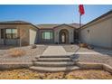 Close-up of the front entrance, showcasing the brick stairs and pathway leading to a welcoming arched doorway at 21717 W South Mountain Ave, Buckeye, AZ 85326