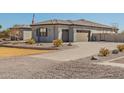 Attached three-car garage with a expansive driveway surrounded by well-maintained desert landscaping at 21717 W South Mountain Ave, Buckeye, AZ 85326