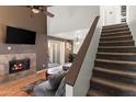 Cozy living room with a fireplace, a ceiling fan, and a staircase leading to the upper level at 222 W Brown Rd # 57, Mesa, AZ 85201