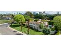 Expansive estate with lush landscaping, pristine lawn, pool, and cityscape backdrop at 2233 N 9Th Ave, Phoenix, AZ 85007