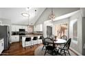 Cozy kitchen and dining area featuring white cabinetry, granite countertops, stainless steel appliances, and stylish pendant lighting at 3119 E Rosemonte Dr, Phoenix, AZ 85050