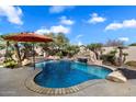 Backyard view of the pool with stone features and beautiful waterfall at 3132 E Harwell Rd, Phoenix, AZ 85042