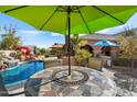 Backyard dining set under a large umbrella next to the pool at 3132 E Harwell Rd, Phoenix, AZ 85042