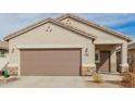 Close up of a two-car garage door with tan stucco and stone accents on the exterior of the home at 35374 W San Sisto Ave, Maricopa, AZ 85138