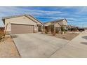 Residential street view with several houses in the neighborhood and a long concrete driveway at 35374 W San Sisto Ave, Maricopa, AZ 85138