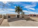 A single-story home with covered parking, a secure gated entry, and desert landscaping in the front at 3611 W Hazelwood St, Phoenix, AZ 85019