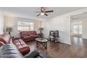 Inviting living room with wood-look floors, modern ceiling fan, and comfortable furnishings at 3611 W Hazelwood St, Phoenix, AZ 85019