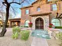 Charming home features a stone archway with decorative iron gate and well-manicured landscaping at 3912 E Williams Dr, Phoenix, AZ 85050