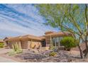 Southwest home features desert landscaping, a three-car garage, and a stucco exterior with stone accents at 40607 N Candlewyck Ln, Phoenix, AZ 85086