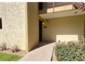 Inviting condo entrance with number 253, featuring a walkway, garden bed, and balcony above at 4630 N 68Th St # 253, Scottsdale, AZ 85251