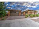 A beautiful front elevation showing the home's two-car garage and brick accents at 4750 S Rhodium Ln, Mesa, AZ 85212