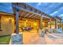 The covered back patio has comfortable seating, a pergola with outdoor lighting, and a built in BBQ at 4750 S Rhodium Ln, Mesa, AZ 85212