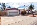 Exterior of a house with desert landscaping, large driveway, and two-car garage at 5043 W Christy Dr, Glendale, AZ 85304