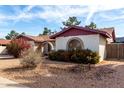 Exterior view of the house with a desert landscape and an arched entry at 5043 W Christy Dr, Glendale, AZ 85304