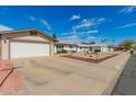 Well-lit, single-story home featuring a two-car garage, desert-style landscaping and a bench at 5256 W Port Au Prince Ln, Glendale, AZ 85306