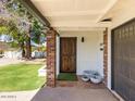 Inviting front porch with brick columns, a decorative front door, and stylish potted plants at 5807 N 18Th St, Phoenix, AZ 85016