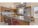 Bright kitchen with stainless steel appliances, granite counters, and an island with seating at 5940 E Taunus Cir, Mesa, AZ 85215