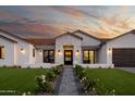 A warm and inviting view of the front exterior featuring a manicured lawn and a stone pathway to the front door at 6312 E Calle Del Paisano --, Scottsdale, AZ 85251