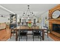 Elegant dining area with a farmhouse table, striking chandelier, and decorative fireplace, adjacent to a modern kitchen at 6440 E Jean Dr, Scottsdale, AZ 85254