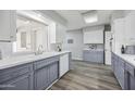 Bright kitchen featuring white countertops, undermount sink, white appliances, grey lower cabinets, and wood-look flooring at 713 E Eason Ave, Buckeye, AZ 85326