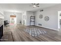 Open living area with fireplace, view to dining area, ceiling fan, and wood-look flooring at 713 E Eason Ave, Buckeye, AZ 85326