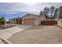 Exterior elevation of a home with a gravel yard, desert landscaping, and a two-car garage at 725 W Hermosa Dr, Wickenburg, AZ 85390