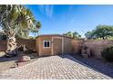 Backyard featuring a storage shed and brick patio at 7365 W Via Del Sol Dr, Glendale, AZ 85310