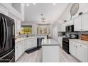 Updated kitchen featuring white cabinets, island, and modern appliances at 7952 E Teton Cir, Mesa, AZ 85207