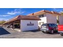 Exterior view of covered parking spaces; cars parked under a carport and building sign present at 100 N Vulture Mine Rd # 103, Wickenburg, AZ 85390