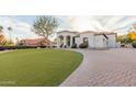 Charming home with lush lawn and beautiful brick driveway with meticulous landscaping at 11628 S Warcloud Ct, Phoenix, AZ 85044