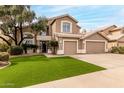 Two-story home featuring a well-manicured lawn and a three-car garage, offering curb appeal at 13566 N 93Rd Pl, Scottsdale, AZ 85260