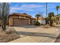 Attractive single-story home showcases desert landscaping, a tile roof, and an attached two-car garage at 16808 N 59Th Pl, Scottsdale, AZ 85254