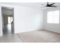 Bright, open living room featuring neutral carpet, a modern ceiling fan, and plenty of natural light at 20471 E Carriage Way, Queen Creek, AZ 85142