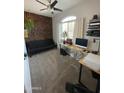 Bright office space with stylish wooden accent wall, a ceiling fan, and a modern desk setup at 20471 E Carriage Way, Queen Creek, AZ 85142