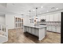 Spacious kitchen with white cabinets, granite countertops, a large kitchen island, and wood-look tile flooring at 21195 W Coronado Rd, Buckeye, AZ 85396