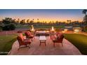 Inviting patio area with comfortable seating and a fire feature, overlooking the golf course at 22020 N San Ramon Dr, Sun City West, AZ 85375