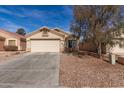 Single-story home with desert landscaping, and a concrete driveway leading to a two-car garage at 23430 W Pima St, Buckeye, AZ 85326