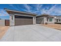 Charming home exterior with a two-car garage, stone accents, and a paved driveway at 24066 S 218Th Pl, Queen Creek, AZ 85142