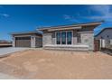 Stylish home exterior featuring gray brick accents, well-maintained landscaping, and a covered entryway at 24066 S 218Th Pl, Queen Creek, AZ 85142