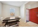 This brightly lit dining area features neutral walls and floors and is situated near the red front door at 30747 W Indianola Ave, Buckeye, AZ 85396