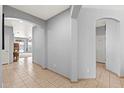 Hallway with tiled flooring and archways leading to various areas, including the pantry, enhancing flow at 337 S 172Nd Dr, Goodyear, AZ 85338