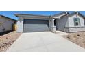 Single-story home with a gray garage door, concrete driveway, neutral stucco, and low-maintenance desert landscaping at 3764 N Camden Dr, Florence, AZ 85132